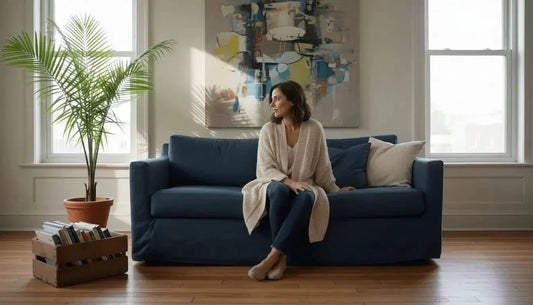 Navyblaue sofa mit passenden kissen und beige strickdecke zeigt bewusste raumgestaltung für zentraleuropäische räume