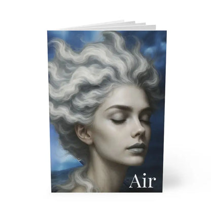 Notizbuch mit Cover zeigt eine ruhige Frau mit wolkigem Haar und dem Wort Luft